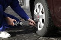 Mechanic checking tire air pressure at car service Royalty Free Stock Photo