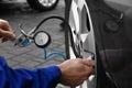 Mechanic checking tire air pressure at car service, closeup Royalty Free Stock Photo