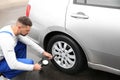 Mechanic checking tire pressure in car wheel Royalty Free Stock Photo