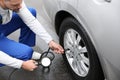 Mechanic checking tire pressure in car wheel at service station Royalty Free Stock Photo