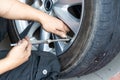 Mechanic checking tire pressure with tyre pressure gauge Royalty Free Stock Photo