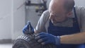 Mechanic checking tire tread depth and wear