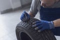 Mechanic checking tire tread depth and wear