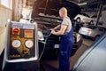 Mechanic checks air conditioning system in car auto service