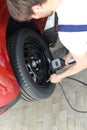 Mechanic checks air pressure from the car tyre in a garage Royalty Free Stock Photo