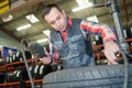 Mechanic checks air pressure from car tyre Royalty Free Stock Photo