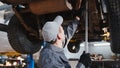 Mechanic checks the suspension in garage automobile service Royalty Free Stock Photo