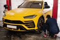 Mechanic checks tire pressure in yellow sport car suv Royalty Free Stock Photo