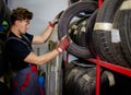 Mechanic choosing tires in a warehouse Royalty Free Stock Photo