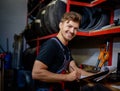 Mechanic choosing tires in a warehouse Royalty Free Stock Photo