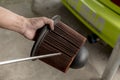 A mechanic cleans the air filter of a diesel engine with a compressed air blower gun Royalty Free Stock Photo