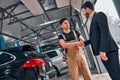 Mechanic with clipboard and man or owner shaking hands at car shop Royalty Free Stock Photo