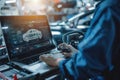 A mechanic conducts computer diagnostics and works on an engine repair inside a well-equipped auto repair shop Royalty Free Stock Photo