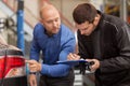 Mechanic and customer looking at car taillight Royalty Free Stock Photo