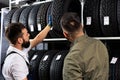 mechanic and customer talking about tire at the repair garage Royalty Free Stock Photo