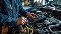 Mechanic Diagnosing Car Engine Issues with OBD Scanner in Auto Repair Shop Royalty Free Stock Photo