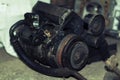 a mechanic disassembles an old dirty car engine on a red lift for repair and tuning turbo car Royalty Free Stock Photo