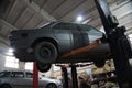 a mechanic disassembles an old dirty car engine on a red lift for repair and tuning turbo car Royalty Free Stock Photo