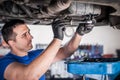 Mechanic discharges motor oil from engine tank under the car Royalty Free Stock Photo