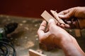 A mechanic does carpenter jobs with wood, plus and other tools. He is hitting hammer on the head of nail to wooden pieces and