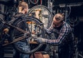 Mechanic doing bicycle wheel service manual in a workshop. Royalty Free Stock Photo