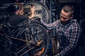 Mechanic doing bicycle wheel service manual in a workshop. Royalty Free Stock Photo