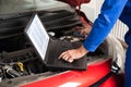 Mechanic Examining Car Engine With Help Of Laptop Royalty Free Stock Photo