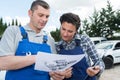 Mechanic and female apprentice looking at exploded diagram