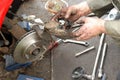 Mechanic fits new brake pads into caliper.