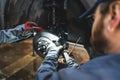 Mechanic fixing car tyres using a screw driver and tools in an auto repair shop Royalty Free Stock Photo