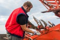 Mechanic fixing plow on the tractor Royalty Free Stock Photo