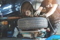 mechanic fixing tire at car repair shop