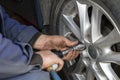 Mechanic without gloves is changing wheel on car with pneumatic wrench or backyard mechanics impact wrench. Close-up Royalty Free Stock Photo
