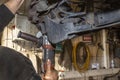 A mechanic grinds, with an angle grinder, the edge of an old rear brake disc in a car, regeneration of the brake system.