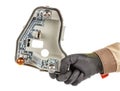 Mechanic hand in black protective glove and brown uniform holding used grey plastic light bulbs holder of car rear light isolated Royalty Free Stock Photo