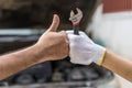 Mechanic hand checking and fixing a broken car in garage.hand o Royalty Free Stock Photo