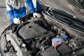 Mechanic hands checking up of serviceability of the car in open hood, close up Royalty Free Stock Photo