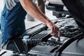 Mechanic hands checking up of serviceability of the car in open hood, close up. Royalty Free Stock Photo