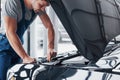 Mechanic hands checking up of serviceability of the car in open hood, close up. Royalty Free Stock Photo