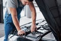 Mechanic hands checking up of serviceability of the car in open hood, close up. Royalty Free Stock Photo