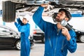 Mechanic and his assistant examining the car bottom with flash light. Auto car repair service center. Professional service Royalty Free Stock Photo