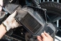 Mechanic holding dirty air filter of big scooter Motorcycles in garage. maintenance,dirty filter decreases amount of air supplied