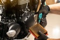 Mechanic holding dirty Engine Air Filter over motorcycle and cleaning Filter with air blow gun .mechanic working in motorcycle Royalty Free Stock Photo