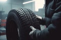 Mechanic holding a tire at the repair garage, Replacement of winter and summer tires AI generated