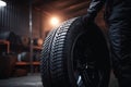 Mechanic holding a tire at the repair garage, Replacement of winter and summer tires AI generated