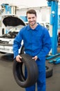 Mechanic holding a tire wheel Royalty Free Stock Photo