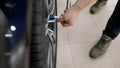 Mechanic in holding a wrench, tighten the wheel bolts. The master tightens the wheels in the auto repair shop, close-up Royalty Free Stock Photo