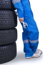 Mechanic holds a wrench and leans on tires Royalty Free Stock Photo