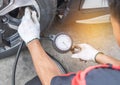 Mechanic inflating put air into the tyre and checking air pressure with gauge pressure Royalty Free Stock Photo