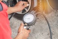 Mechanic inflating put air into the tyre and checking air pressure with gauge pressure Royalty Free Stock Photo